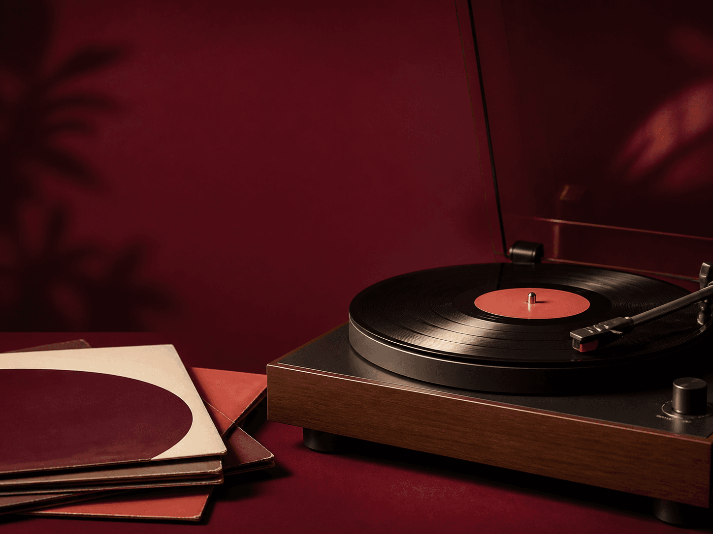 Toca-discos com um vinil e capas de discos em um ambiente vinho